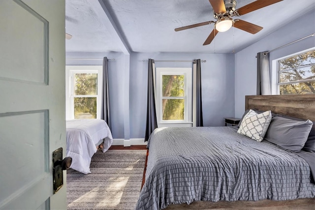 bedroom with multiple windows, baseboards, and a ceiling fan