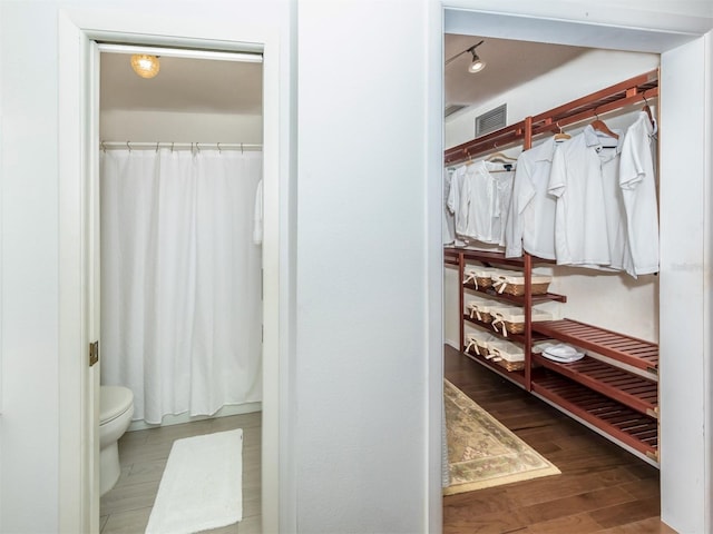 full bath with toilet, wood finished floors, and visible vents