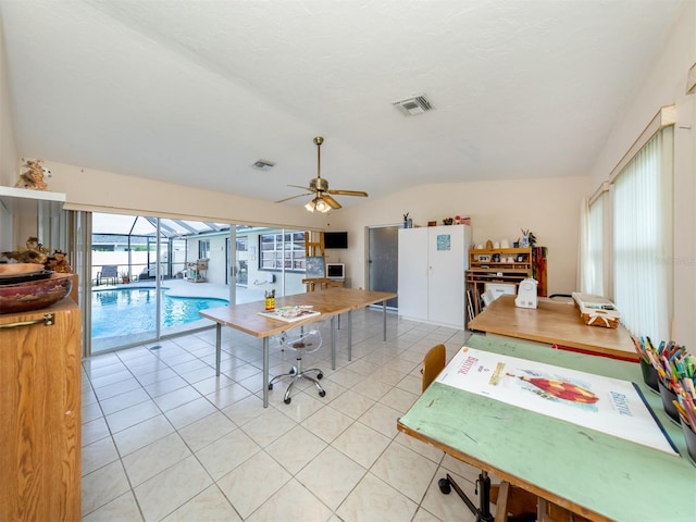 kitchen featuring lofted ceiling, light tile patterned floors, a wealth of natural light, and visible vents