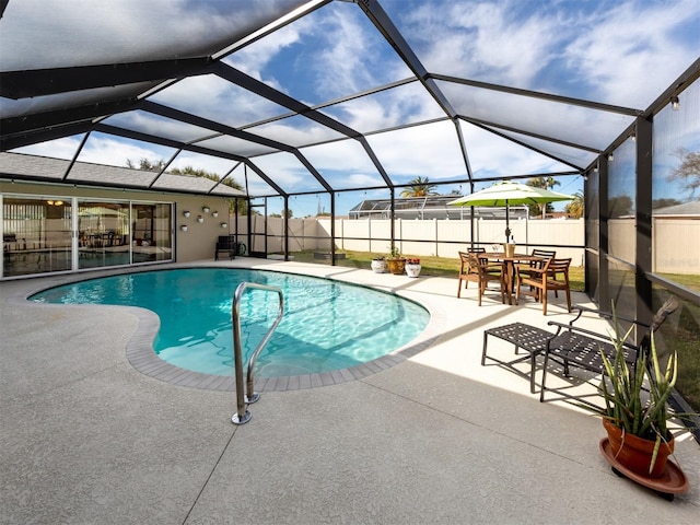 view of swimming pool with glass enclosure, a patio area, a fenced backyard, and a fenced in pool