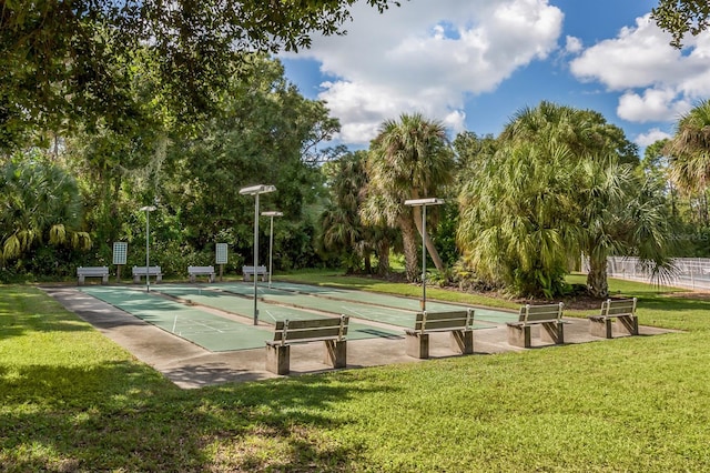 view of home's community with shuffleboard and a lawn