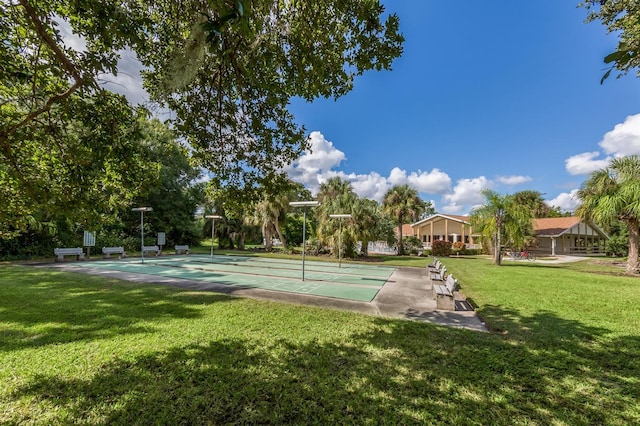 surrounding community featuring shuffleboard and a yard