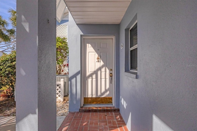 view of exterior entry with stucco siding