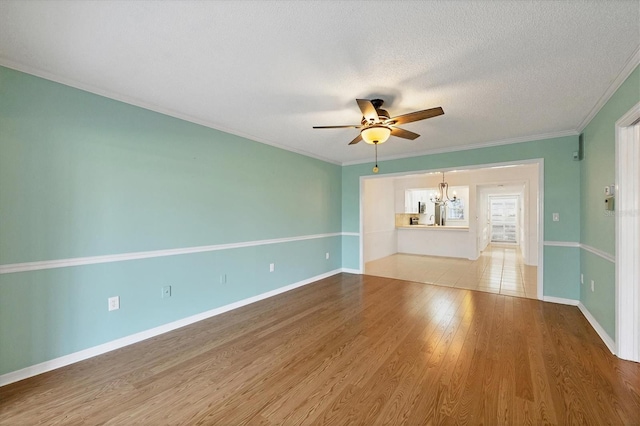 unfurnished living room featuring baseboards, ornamental molding, wood finished floors, a textured ceiling, and ceiling fan with notable chandelier