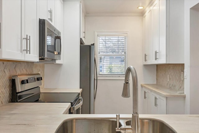 kitchen with appliances with stainless steel finishes, light countertops, decorative backsplash, and white cabinetry