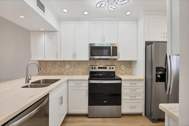 kitchen featuring a sink, visible vents, white cabinets, appliances with stainless steel finishes, and tasteful backsplash