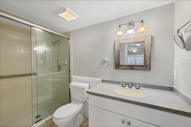 bathroom featuring vanity, a shower stall, and toilet