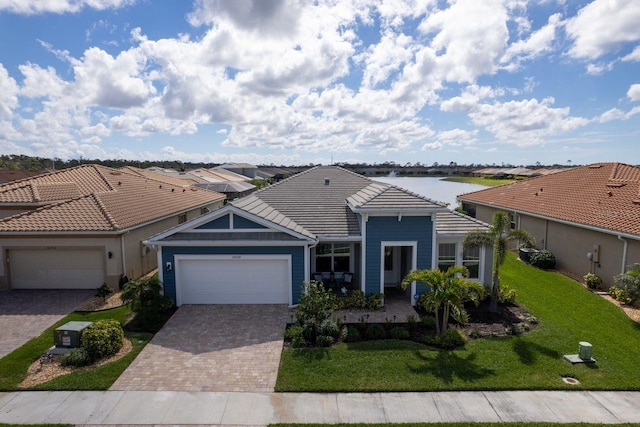 view of front of home featuring a garage, a front yard, decorative driveway, and a tile roof