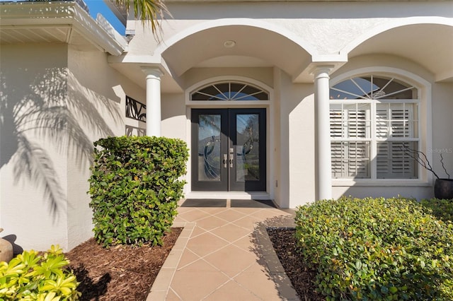 view of exterior entry with french doors and stucco siding