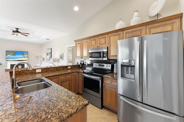 kitchen featuring light tile patterned flooring, recessed lighting, a sink, appliances with stainless steel finishes, and dark stone counters