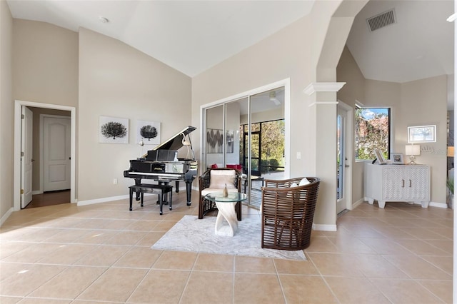 sitting room with high vaulted ceiling, baseboards, visible vents, and light tile patterned flooring