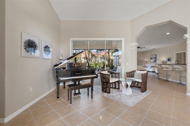 sitting room with arched walkways, ceiling fan, light tile patterned flooring, baseboards, and decorative columns