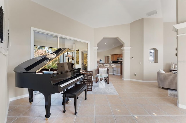 sitting room with lofted ceiling, light tile patterned flooring, decorative columns, and baseboards