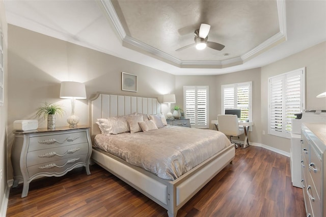 bedroom with dark wood-style floors, a tray ceiling, and ornamental molding