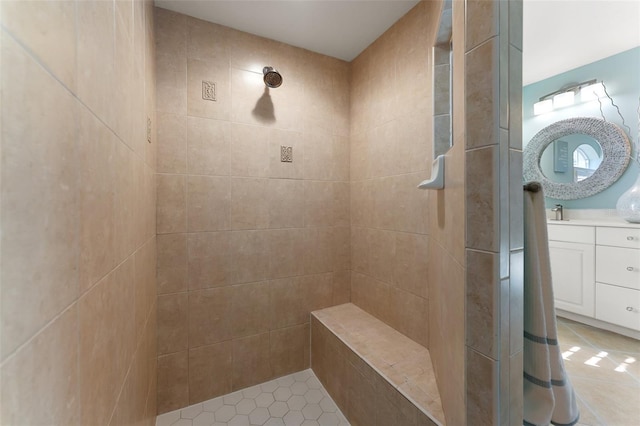 full bath featuring a tile shower, vanity, and tile patterned floors