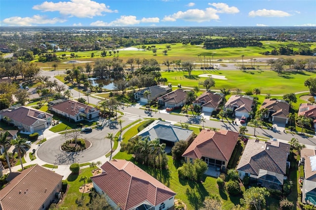 drone / aerial view featuring view of golf course and a residential view