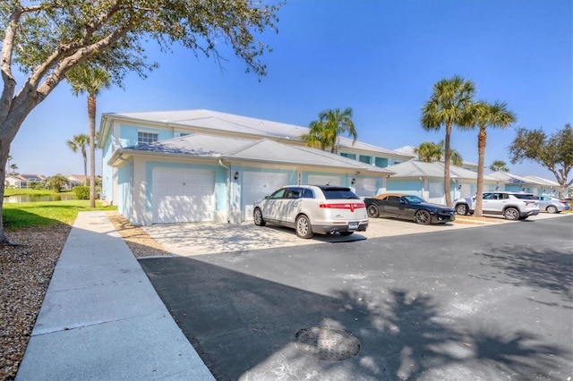 multi unit property featuring a garage and driveway