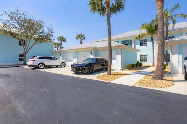 view of front of home with a garage, driveway, and stucco siding