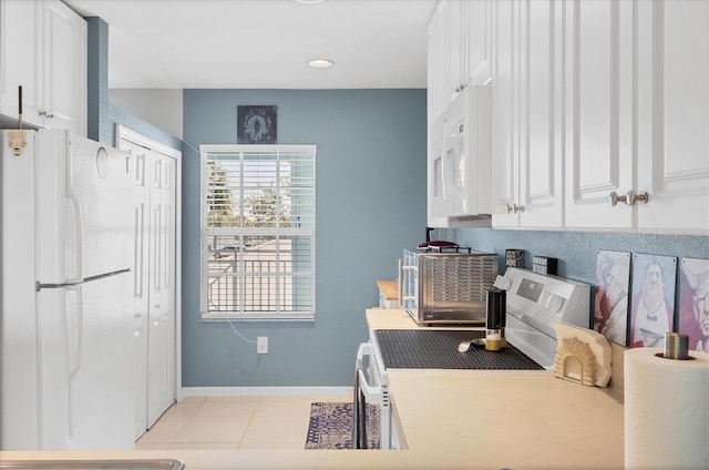 kitchen with white appliances, light tile patterned floors, baseboards, white cabinets, and light countertops