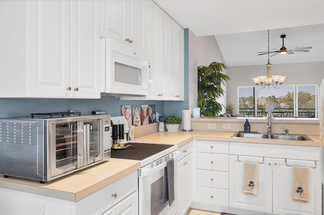 kitchen featuring a toaster, white appliances, a sink, and white cabinets