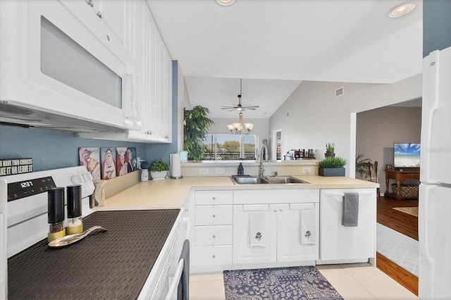 kitchen with a notable chandelier, a peninsula, white appliances, a sink, and visible vents