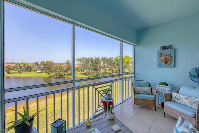 sunroom featuring a water view