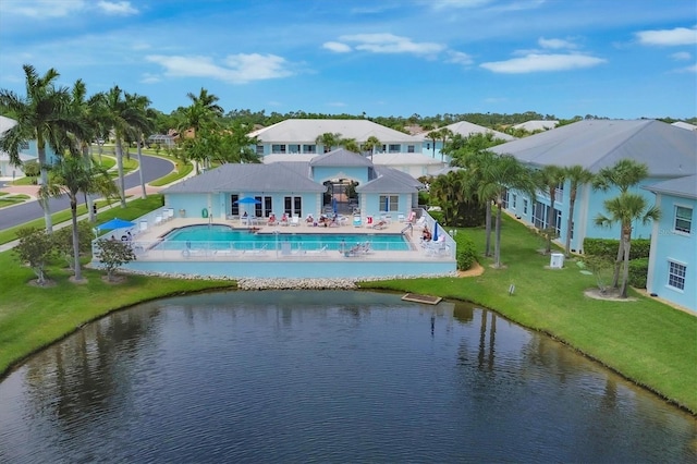 rear view of property featuring a yard, a patio area, a community pool, and a water view