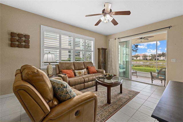 living room featuring light tile patterned flooring, a ceiling fan, and a healthy amount of sunlight