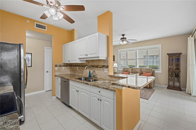 kitchen with visible vents, white cabinets, appliances with stainless steel finishes, a peninsula, and a sink