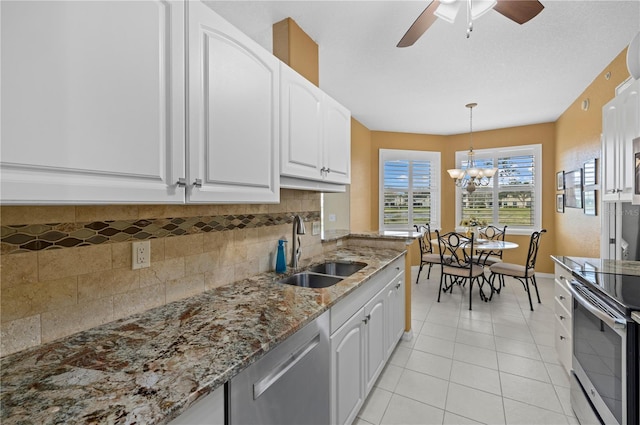 kitchen featuring stainless steel appliances, a sink, white cabinetry, and pendant lighting