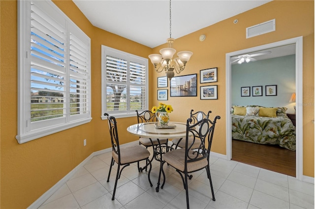 dining area with ceiling fan with notable chandelier, visible vents, baseboards, and light tile patterned floors