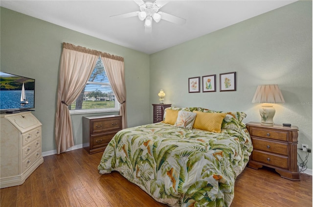 bedroom with a ceiling fan, baseboards, and wood finished floors