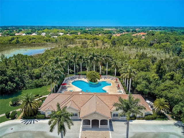 view of swimming pool featuring a water view and a view of trees