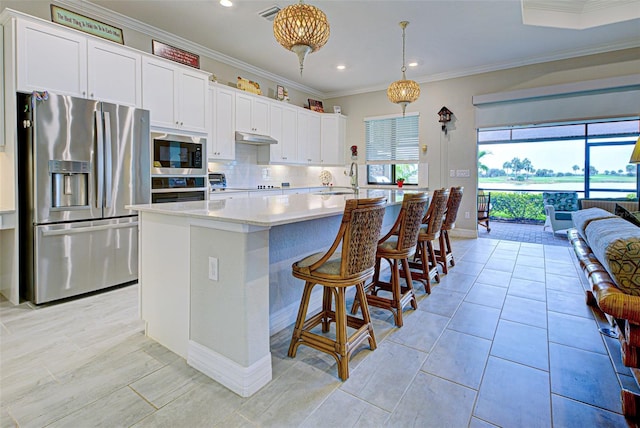 kitchen featuring white cabinets, open floor plan, hanging light fixtures, built in microwave, and stainless steel fridge