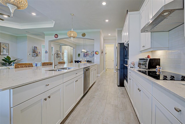 kitchen featuring arched walkways, a sink, white cabinets, appliances with stainless steel finishes, and wall chimney exhaust hood