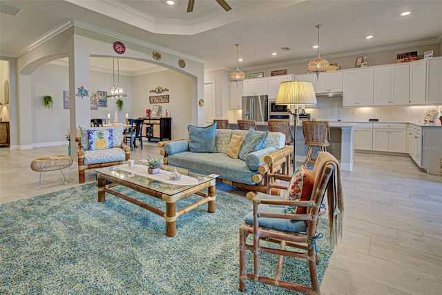 living room featuring arched walkways, ceiling fan, ornamental molding, and visible vents