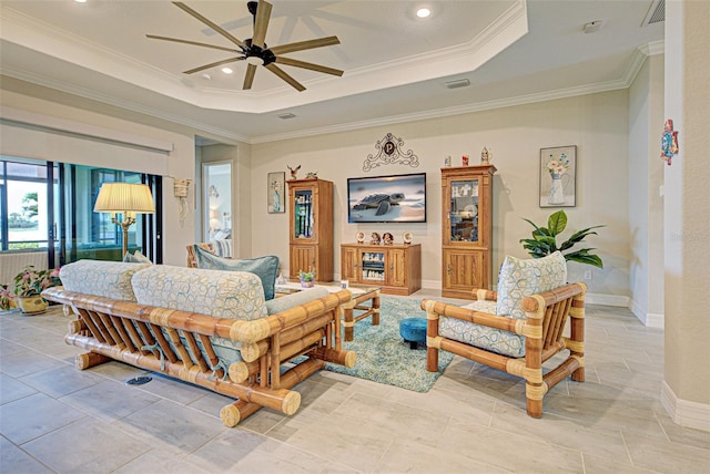 bedroom with baseboards, a tray ceiling, visible vents, and crown molding