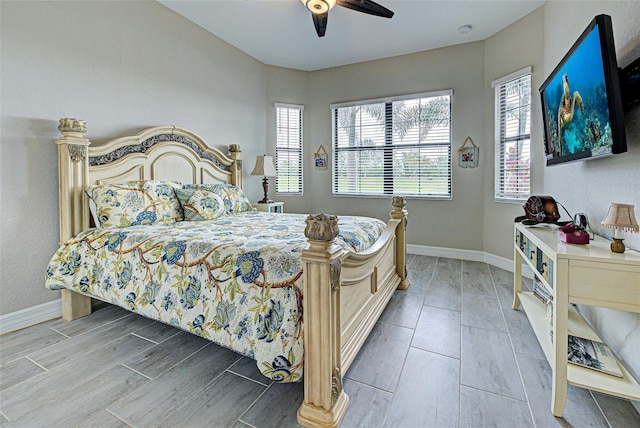 bedroom featuring wood tiled floor, baseboards, and a ceiling fan