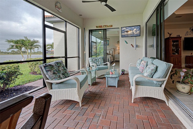 sunroom / solarium featuring a water view and ceiling fan