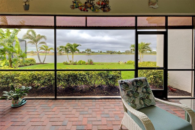 sunroom / solarium featuring a water view