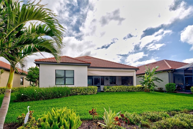 view of front of property featuring a lanai, a tile roof, a front lawn, and stucco siding