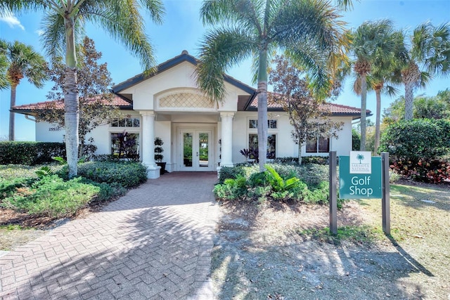 mediterranean / spanish-style house with a tiled roof, french doors, and stucco siding