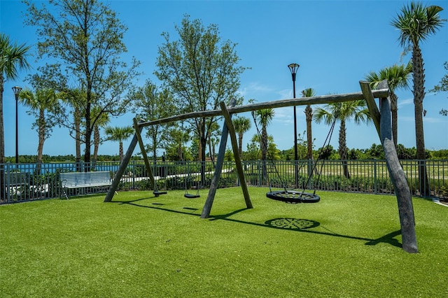 view of jungle gym featuring fence and a yard