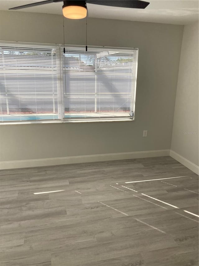 spare room featuring wood finished floors and baseboards