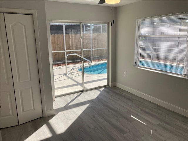 spare room featuring ceiling fan, baseboards, and wood finished floors