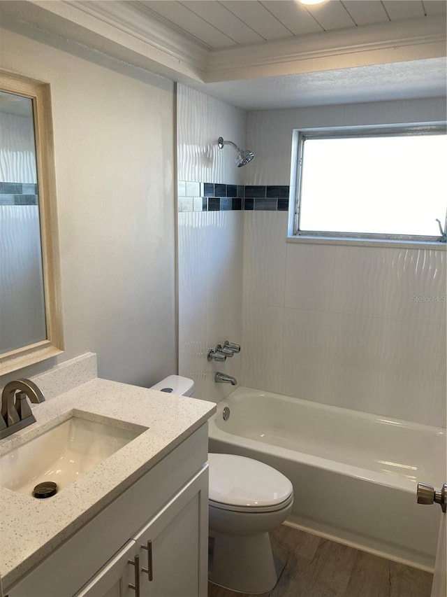 full bathroom with toilet, wood finished floors, vanity, ornamental molding, and shower / bathing tub combination