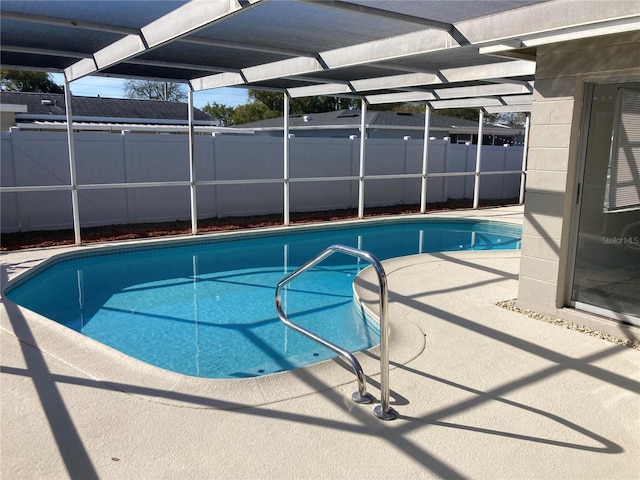 view of swimming pool with glass enclosure, a patio, fence, and a fenced in pool