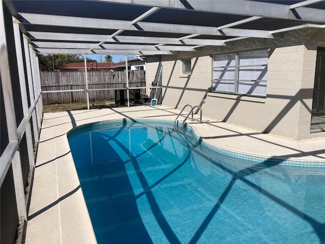 view of swimming pool featuring a lanai, fence, a fenced in pool, and a patio