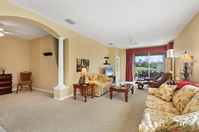 living area with arched walkways, visible vents, ceiling fan, and ornate columns