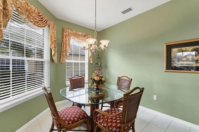 dining area with baseboards, light tile patterned floors, visible vents, and an inviting chandelier